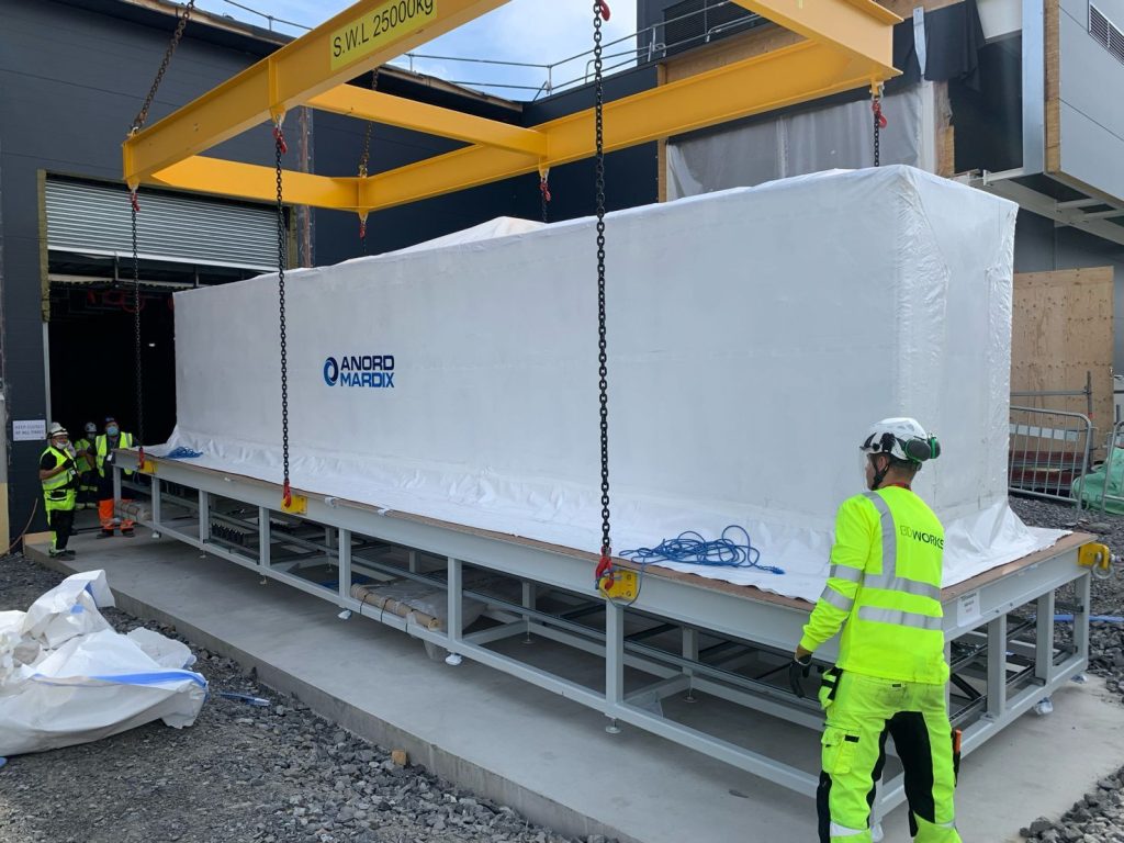 large white machine being lifted and moved