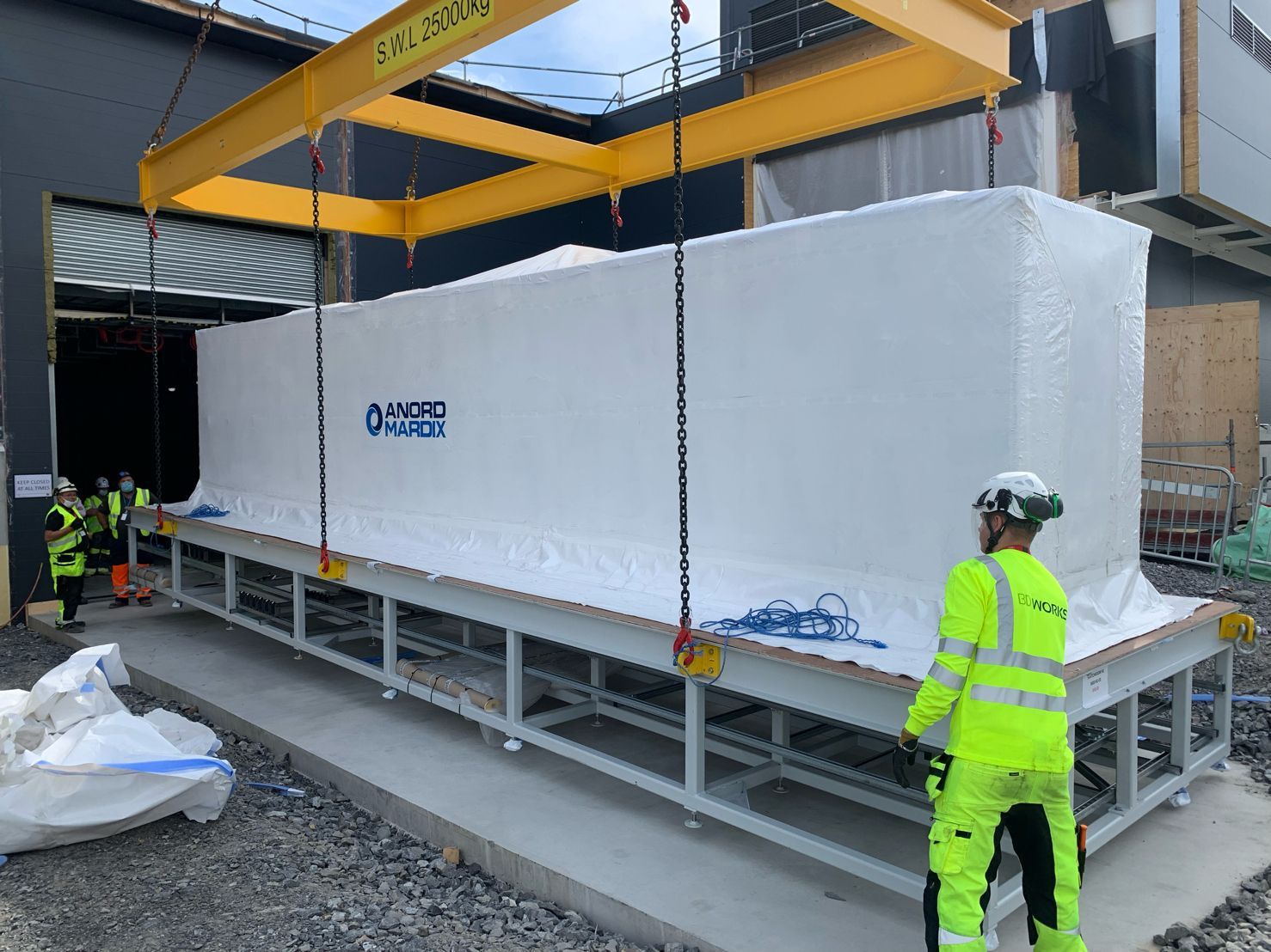 large white machine being lifted and moved