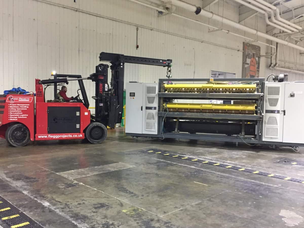 machinery being moved in a factory with a forklift