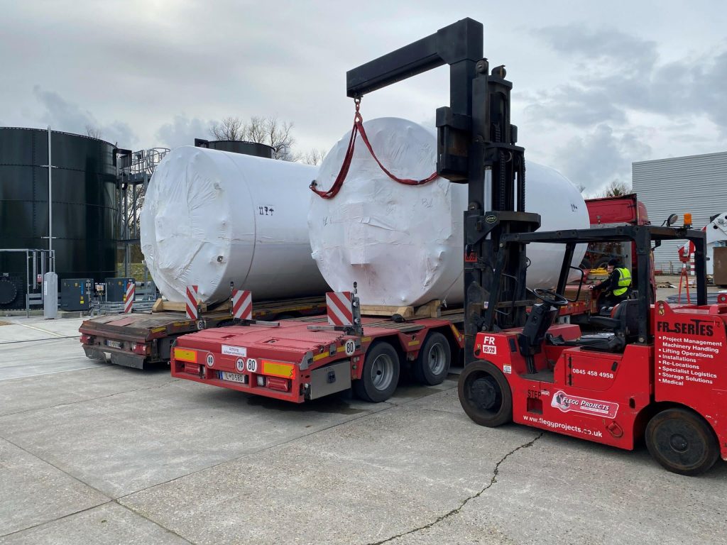 large holding tanks about to be lifted with forklift