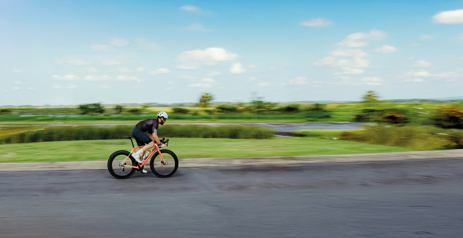 Cyclist on rural road near industrial area